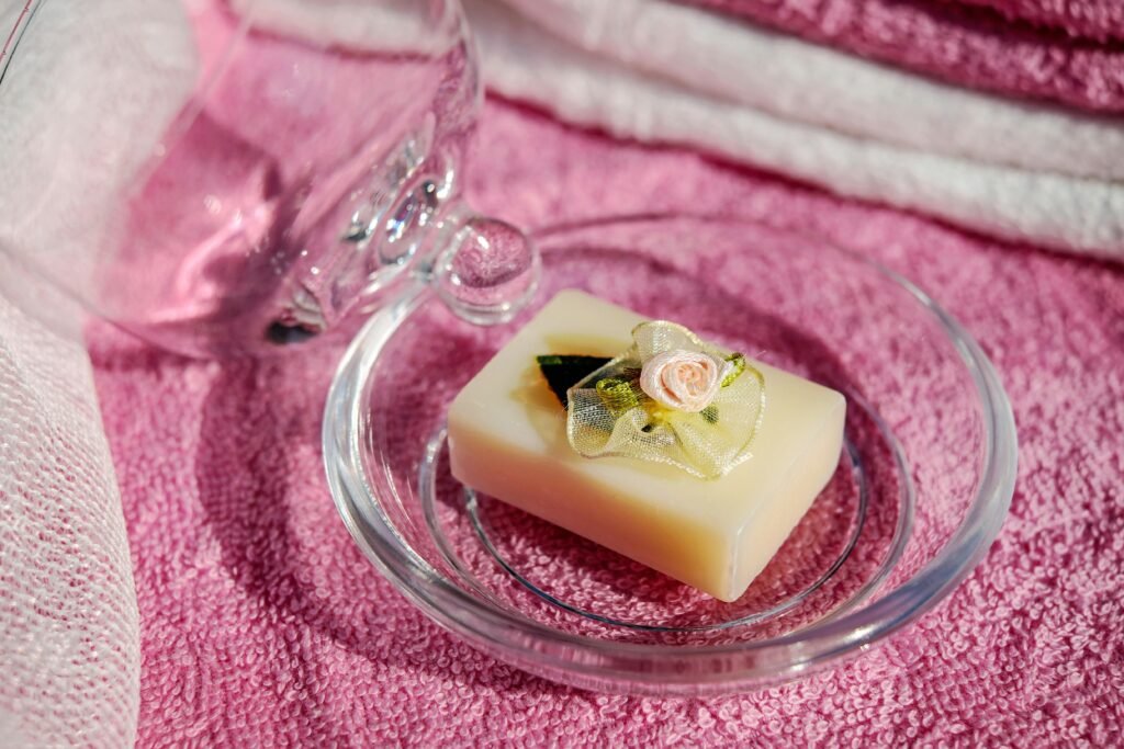 Elegant soap bar with floral decor on a pink towel, evoking relaxation and beauty.