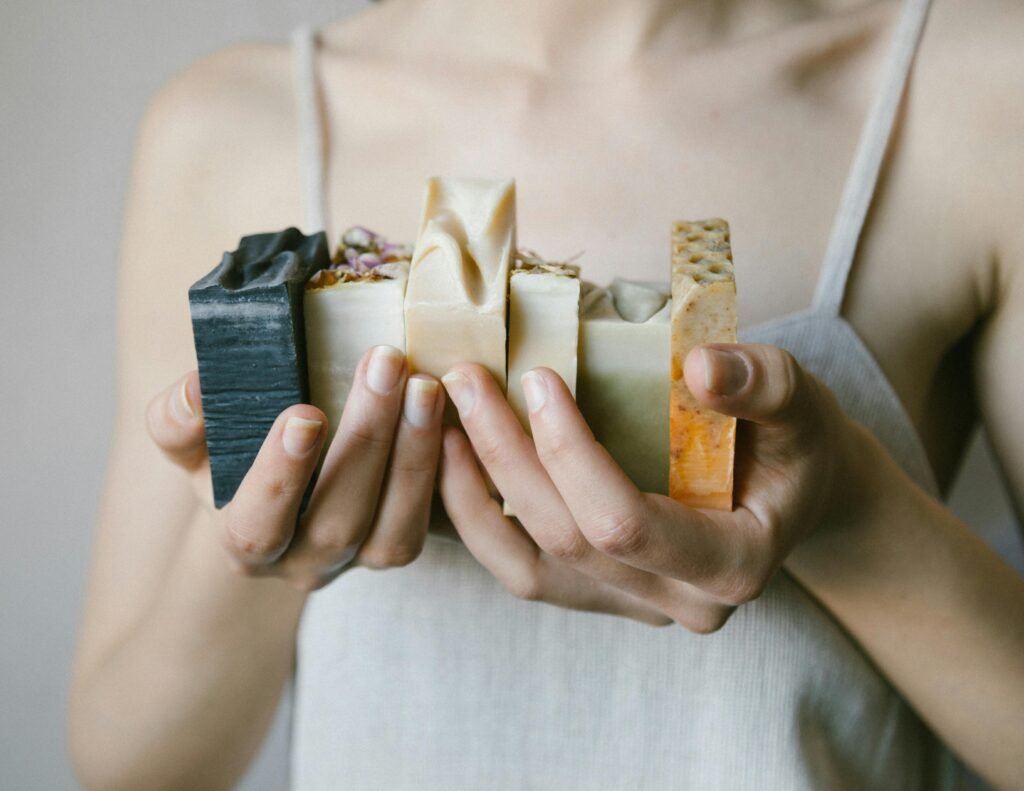 Diverse natural soap bars held delicately by a person, showcasing eco-friendly skincare options.